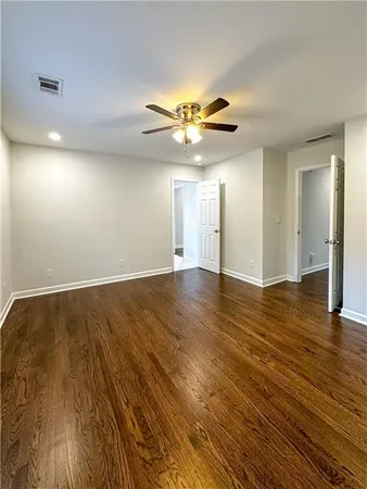 a view of an empty room with window and wooden floor