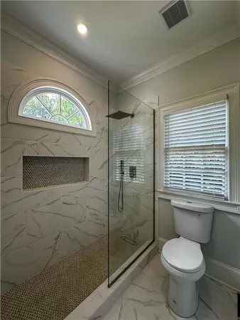 a bathroom with a toilet sink a shower and a window