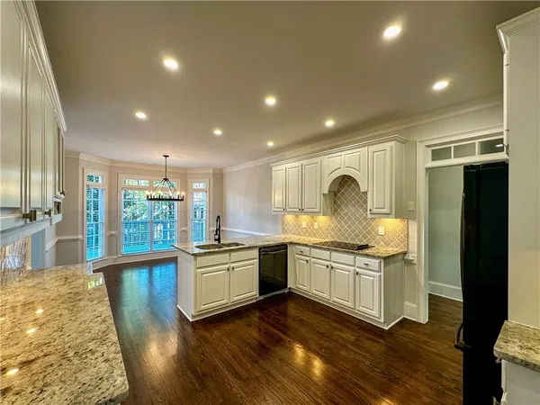 a kitchen with stainless steel appliances granite countertop a stove and a wooden floors