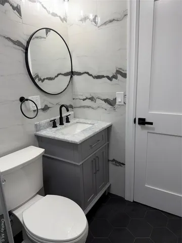 a bathroom with a toilet a sink and a mirror