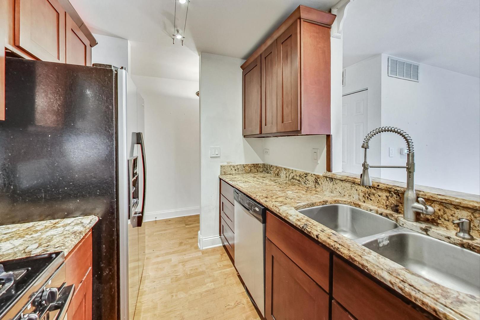 1931 Prairie Square, Unit 108 Schaumburg, IL 60173 - Photo 19 of 40 a kitchen with stainless steel appliances granite countertop a sink and a refrigerator