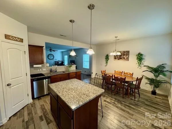 a kitchen with stainless steel appliances granite countertop table chairs and a refrigerator