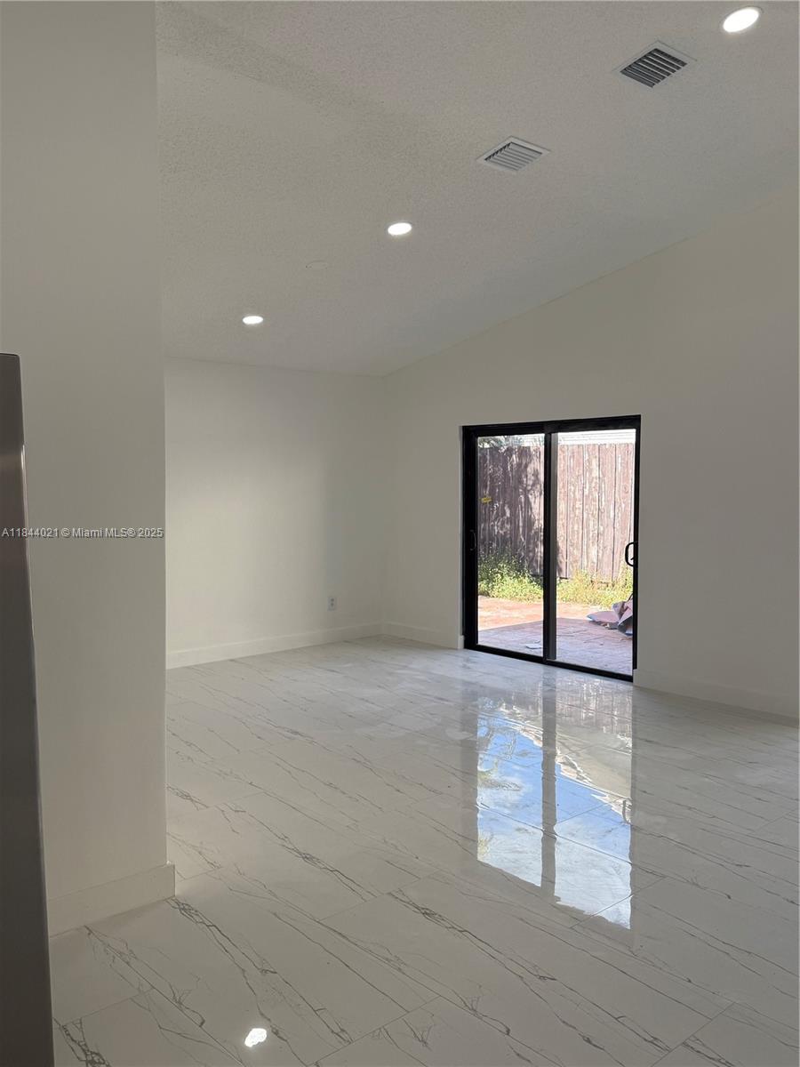 15921 Southwest 82nd Street Miami, FL 33193 - Photo 14 of 22 an empty room with windows and painted walls