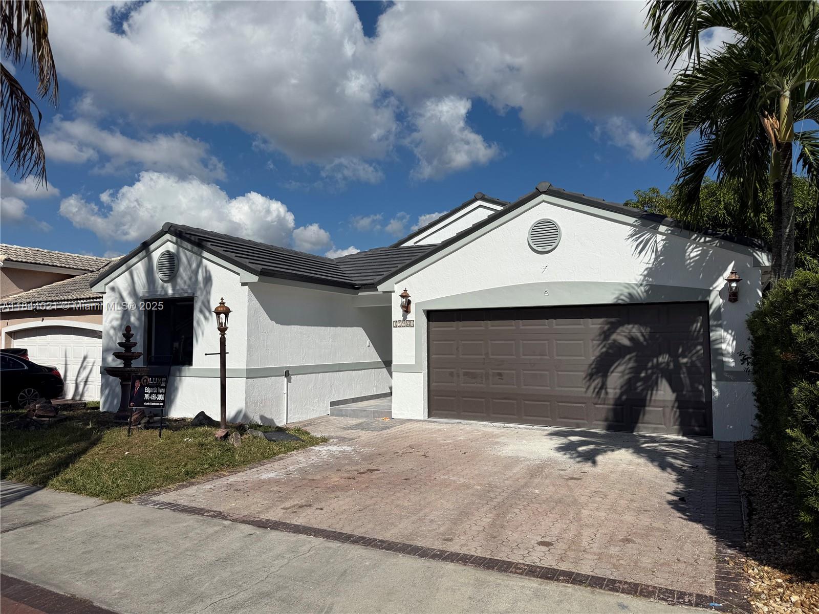 15921 Southwest 82nd Street Miami, FL 33193 - Photo 5 of 22 a front view of a house with a yard and garage