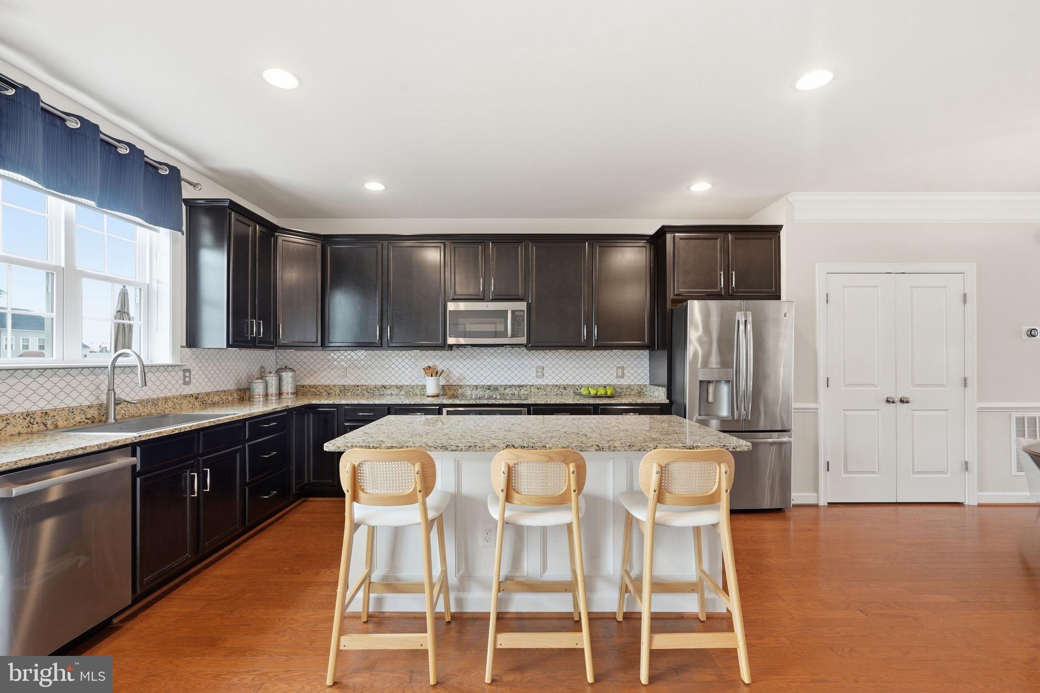 204 Miles Hawk Terrace Purcellville, VA 20132 - Photo 11 of 40 a kitchen with stainless steel appliances granite countertop a stove a sink a refrigerator white cabinets and a refrigerator