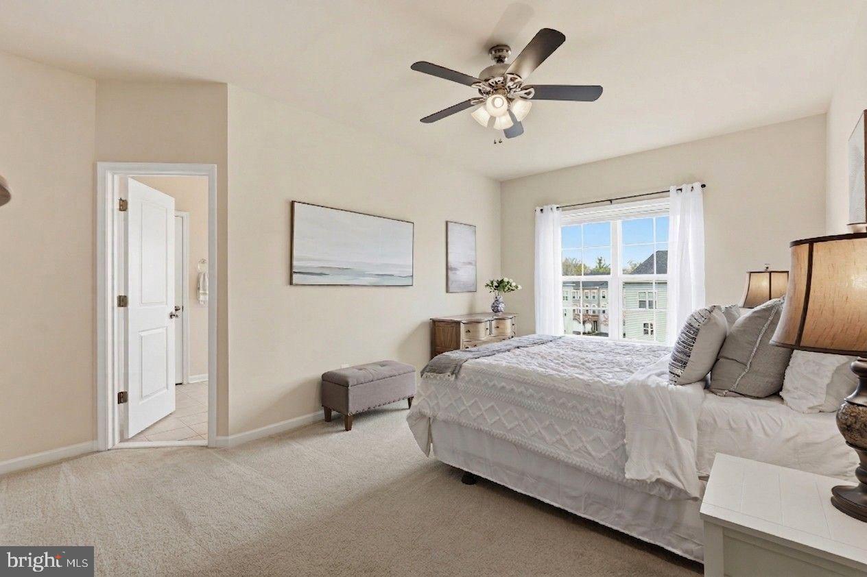 204 Miles Hawk Terrace Purcellville, VA 20132 - Photo 22 of 40 a bedroom with a large bed a chandelier and a window