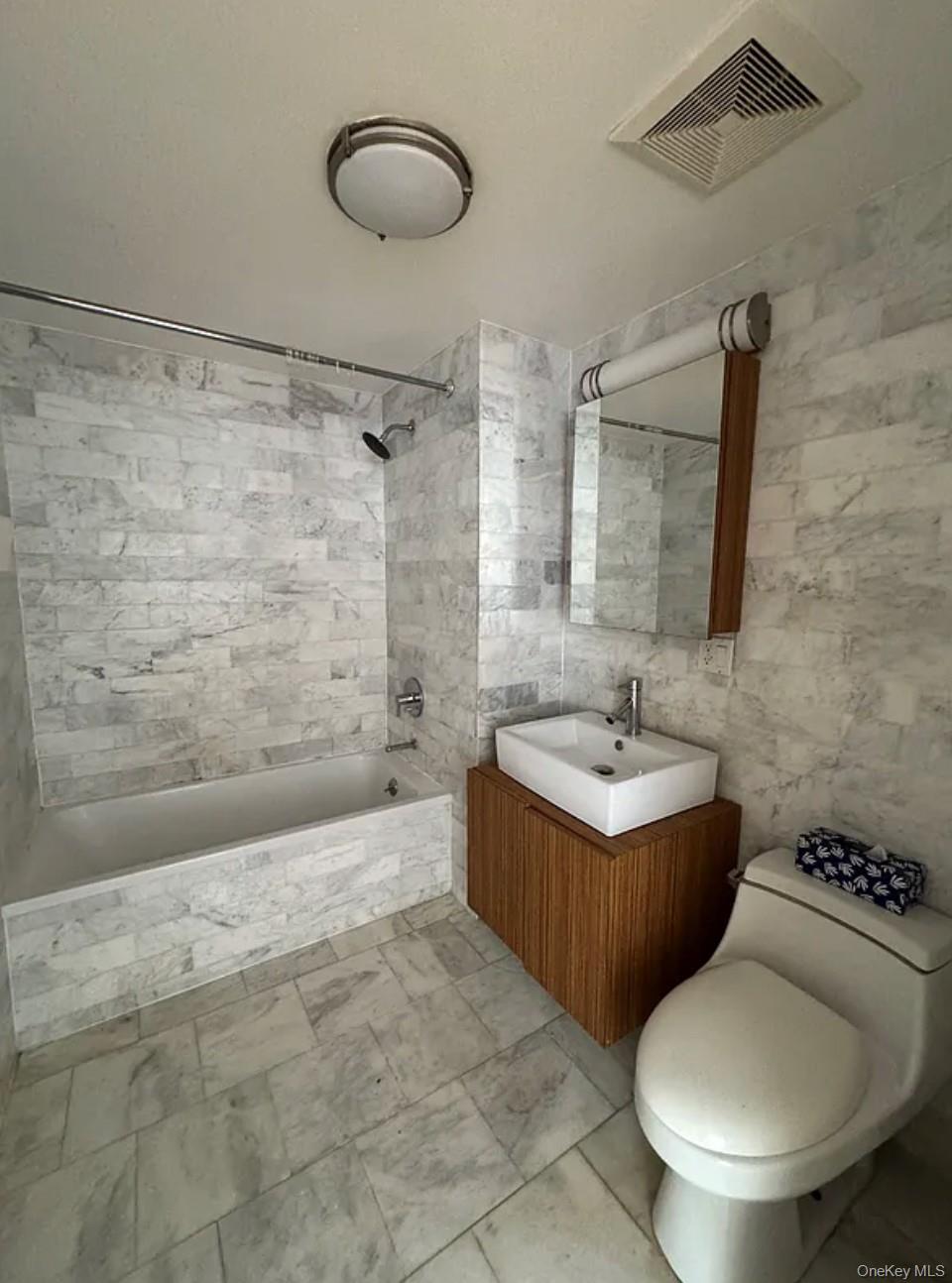 112-02 Northern Boulevard, Unit 6C Queens, NY 11368 - Photo 5 of 6 a bathroom with a granite countertop sink a toilet and shower