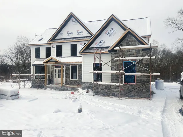 a front view of a house with a yard covered in snow