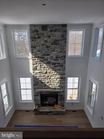 an empty room with wooden floor fireplace and windows