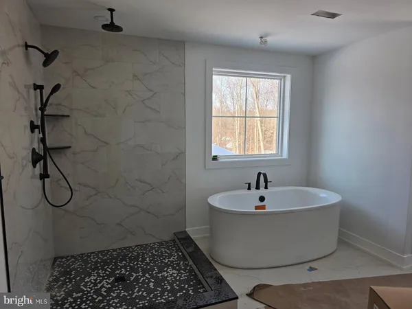 a white bath tub sitting in a bathroom next to a window