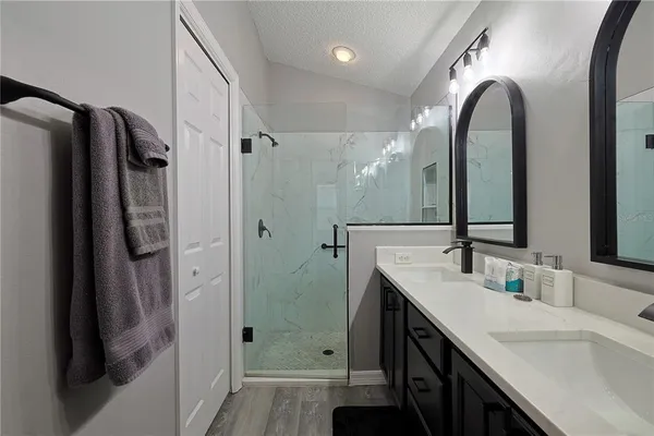 a bathroom with a double vanity sink mirror and shower