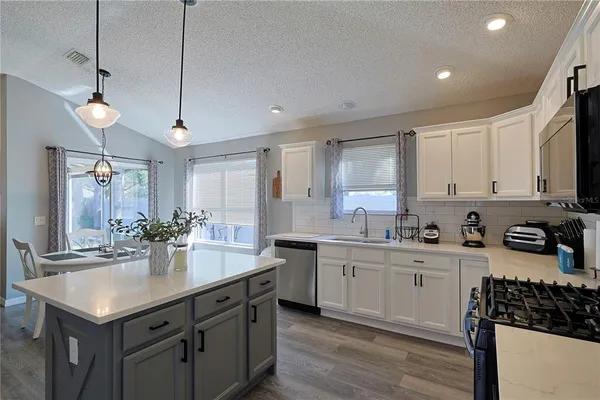 a kitchen with sink stove and cabinets