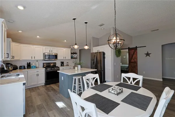 a large kitchen with a table and chairs