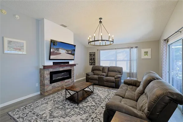a living room with furniture a fireplace and a flat screen tv