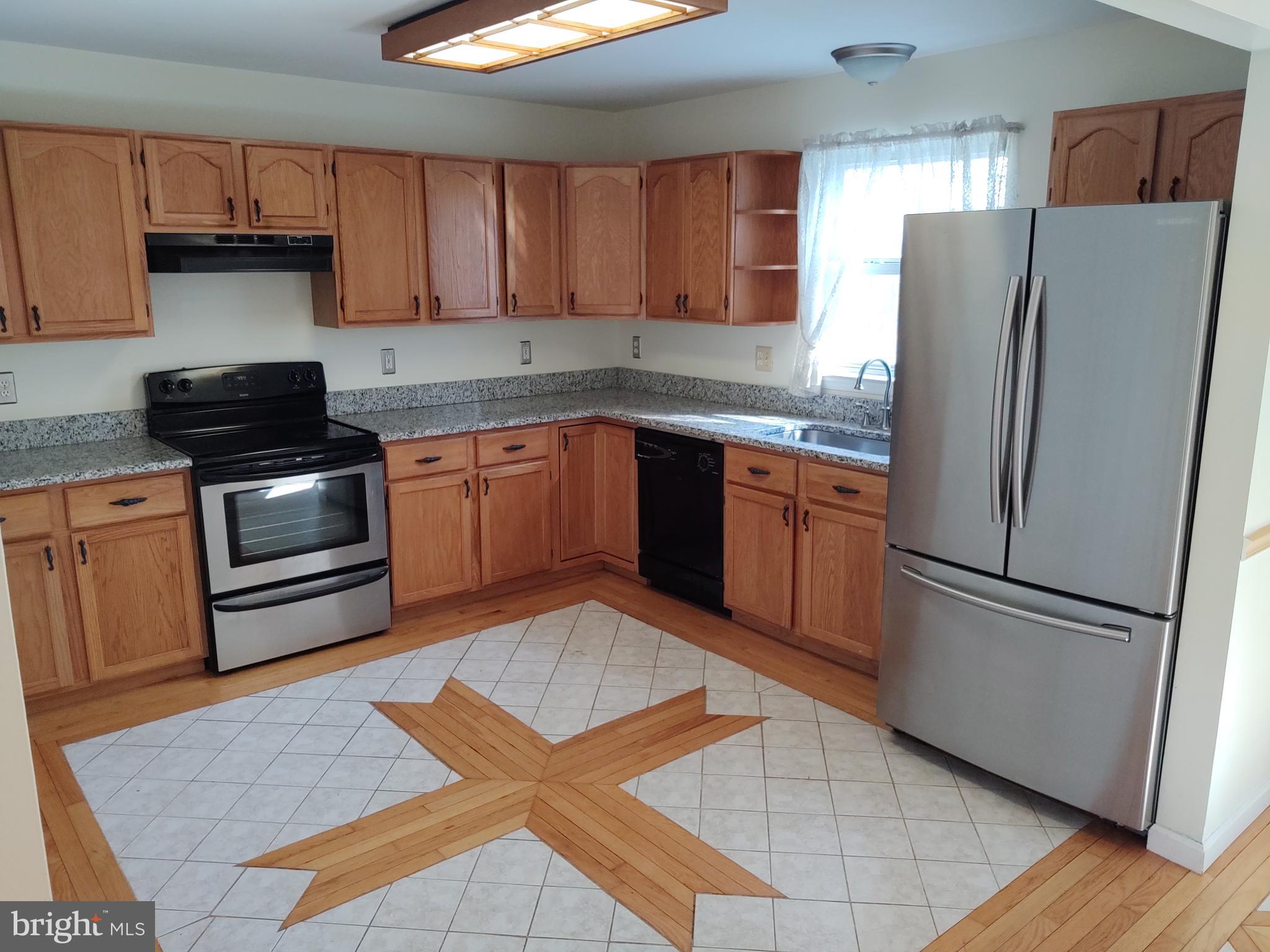 609 Mann Road Deale, MD 20751 - Photo 4 of 24 a kitchen with stainless steel appliances granite countertop a refrigerator sink and stove