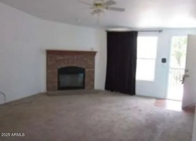 an empty room with windows and fireplace