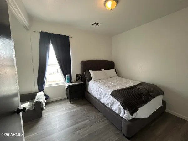 a bedroom with a bed and wooden floor