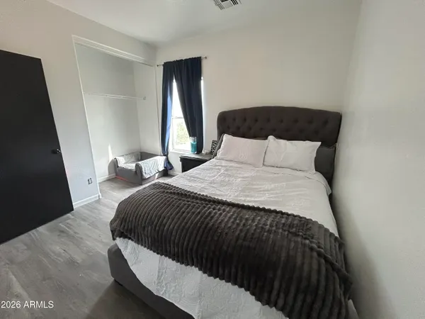a bedroom with a bed and a refrigerator