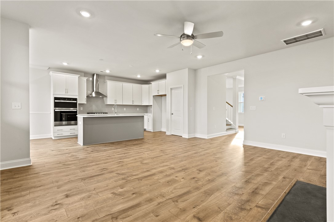 134 Anderson Oaks Lane, Unit 84 Easley, SC 29642 - Photo 11 of 43 This bright kitchen with an island flows into an open living area with rich hardwood flooring.