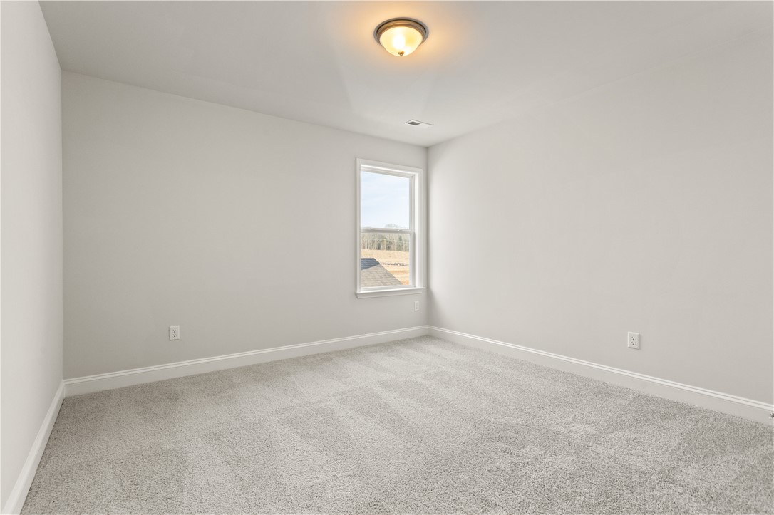134 Anderson Oaks Lane, Unit 84 Easley, SC 29642 - Photo 31 of 43 Bright and airy room featuring soft carpeting and ample natural light through a single window.