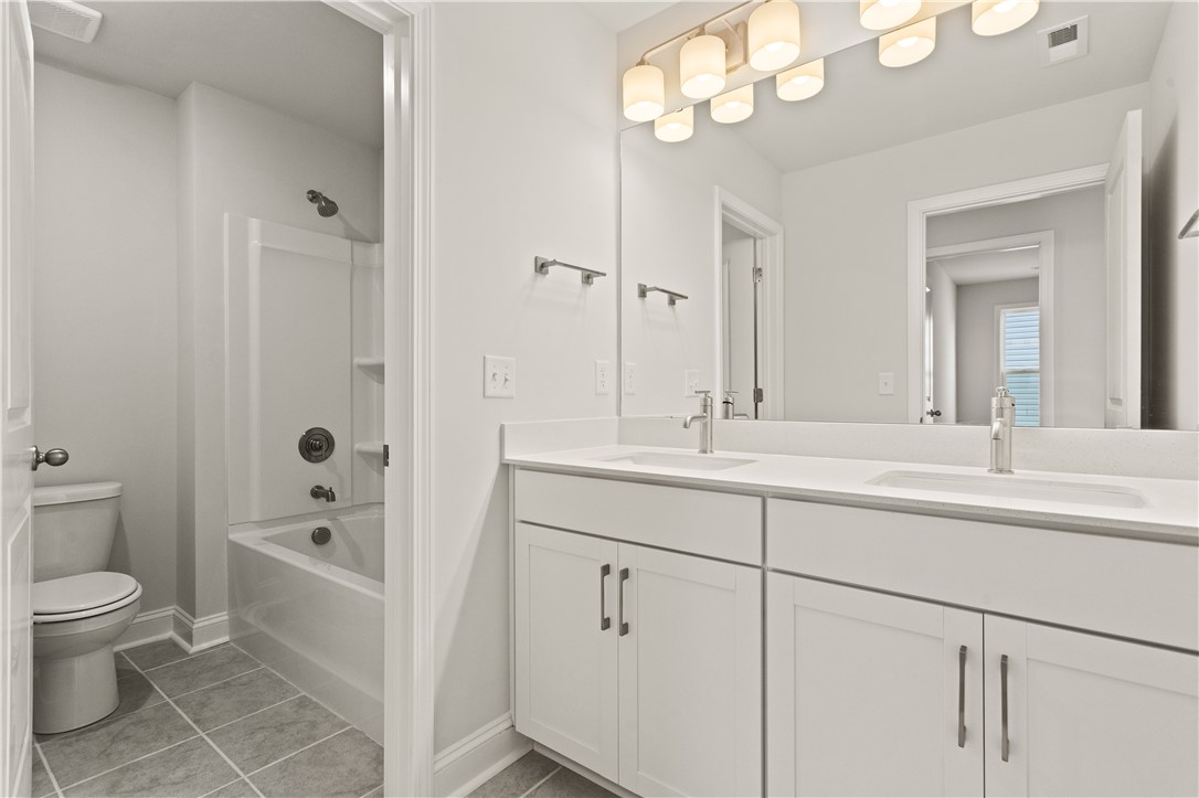 134 Anderson Oaks Lane, Unit 84 Easley, SC 29642 - Photo 33 of 43 This bright bathroom features a dual vanity and a clean shower and tub combination.