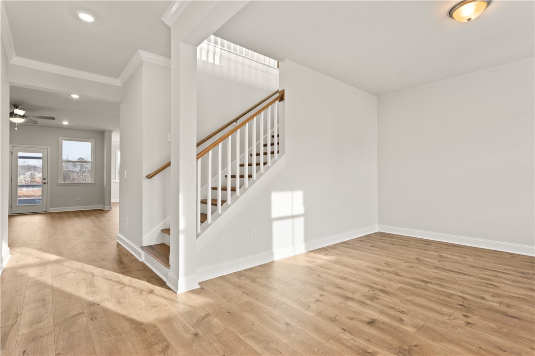 134 Anderson Oaks Lane, Unit 84 Easley, SC 29642 - Photo 6 of 43 This bright interior features elegant wood flooring and an inviting staircase, creating a warm ambiance.