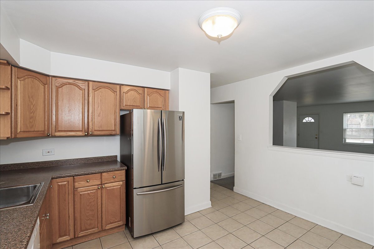449 Elmhurst Road Mount Prospect, IL 60056 - Photo 11 of 26 a kitchen with stainless steel appliances granite countertop a refrigerator and a stove top oven