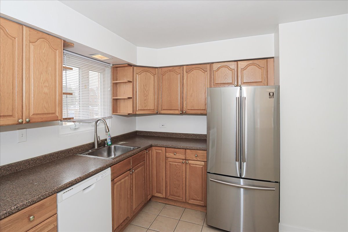 449 Elmhurst Road Mount Prospect, IL 60056 - Photo 9 of 26 a kitchen with a refrigerator sink and cabinets