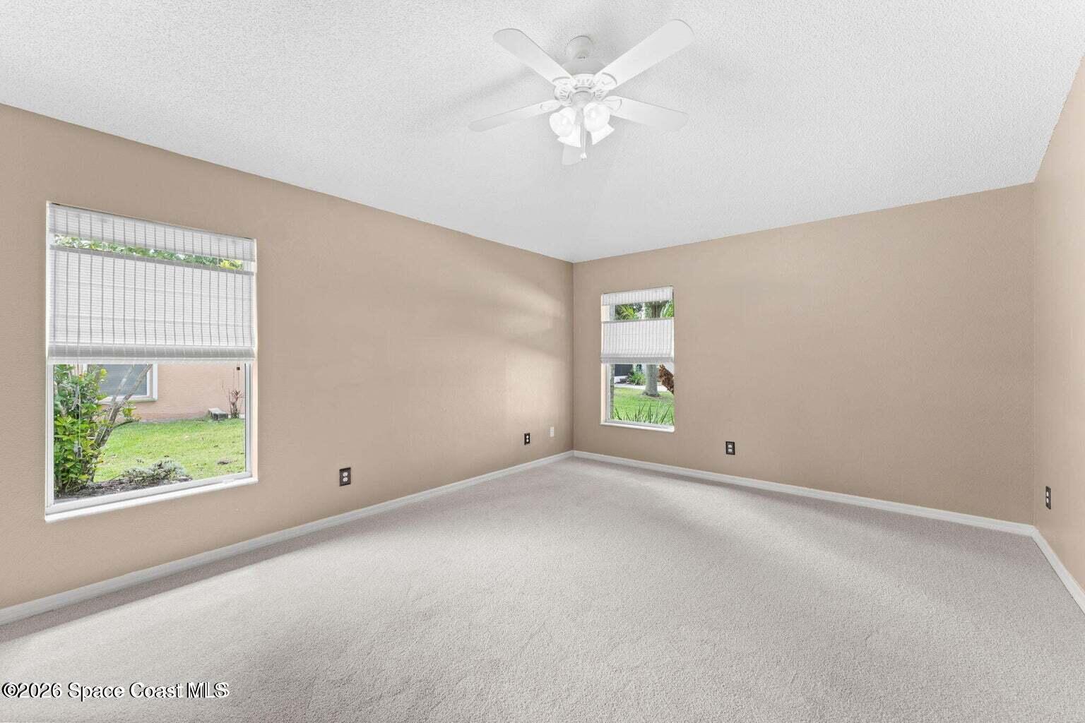 4741 Decatur Circle Melbourne, FL 32934 - Photo 17 of 44 an empty room with windows and fan