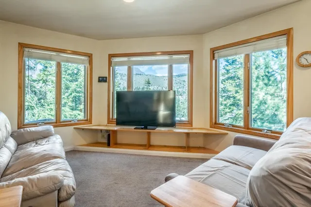 a living room with furniture and large windows