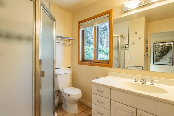 a bathroom with a granite countertop sink toilet and shower