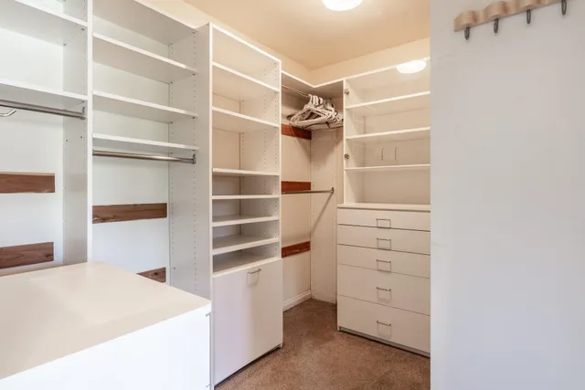 a view of walk in closet with empty racks