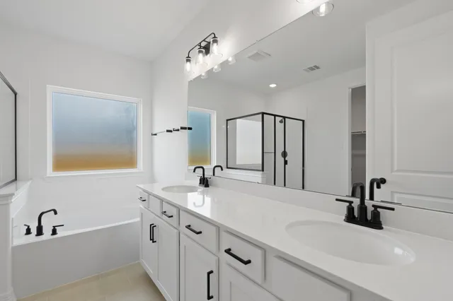 a bathroom with a tub sink and mirror