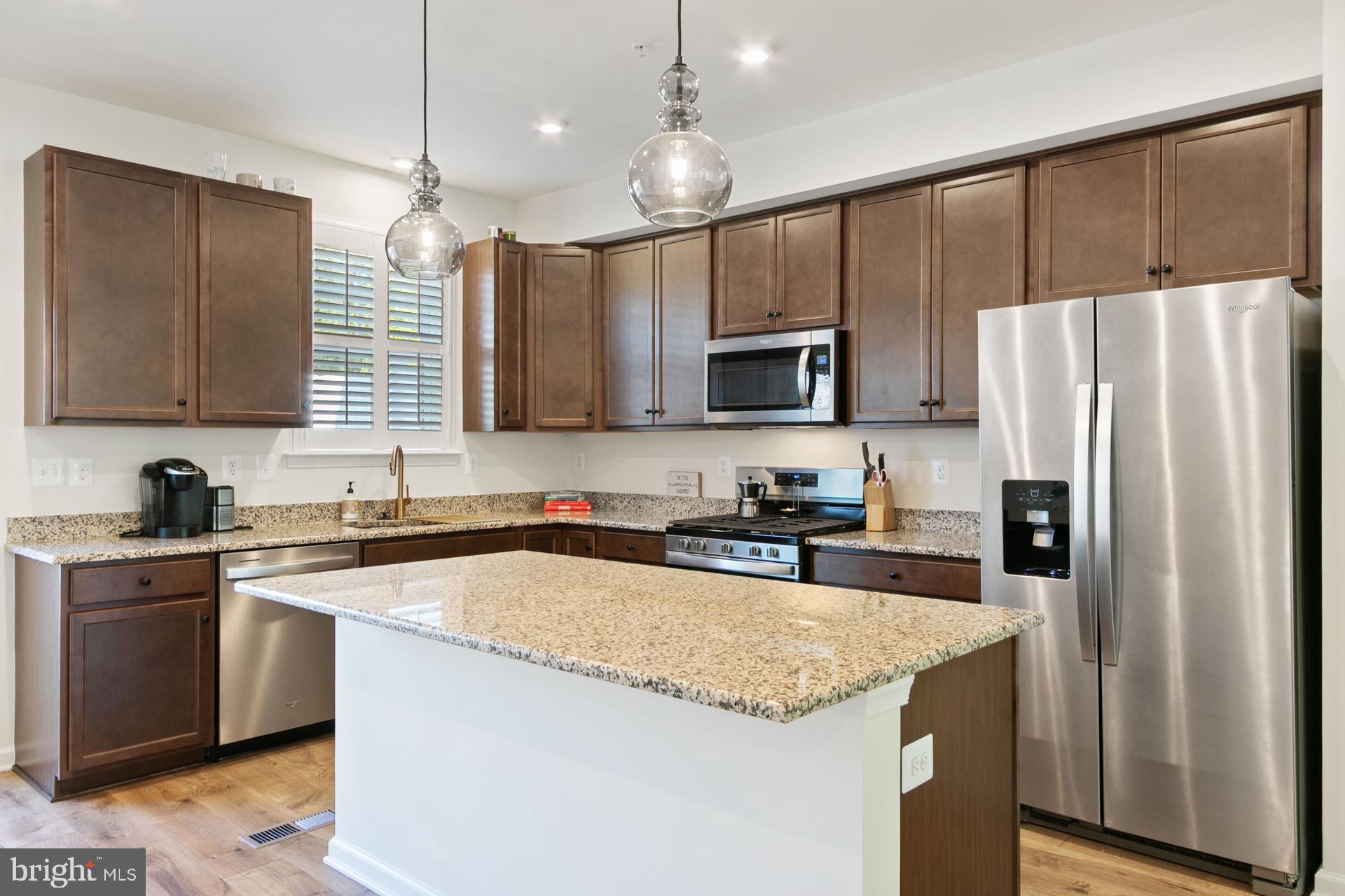 340 Shipyard Drive Cambridge, MD 21613 - Photo 11 of 35 a kitchen with stainless steel appliances granite countertop a refrigerator a sink dishwasher a stove top oven a kitchen island and couches with wooden floor