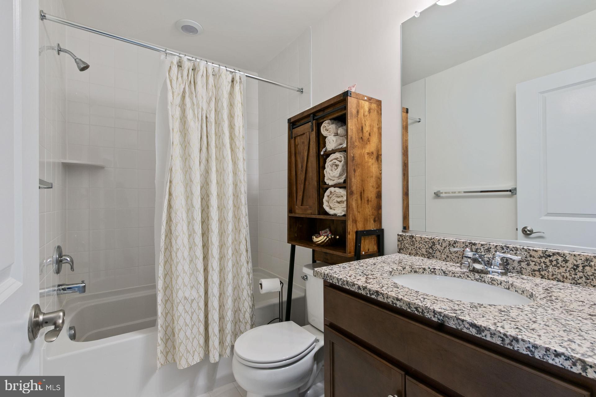 340 Shipyard Drive Cambridge, MD 21613 - Photo 31 of 35 a bathroom with a granite countertop sink toilet and shower