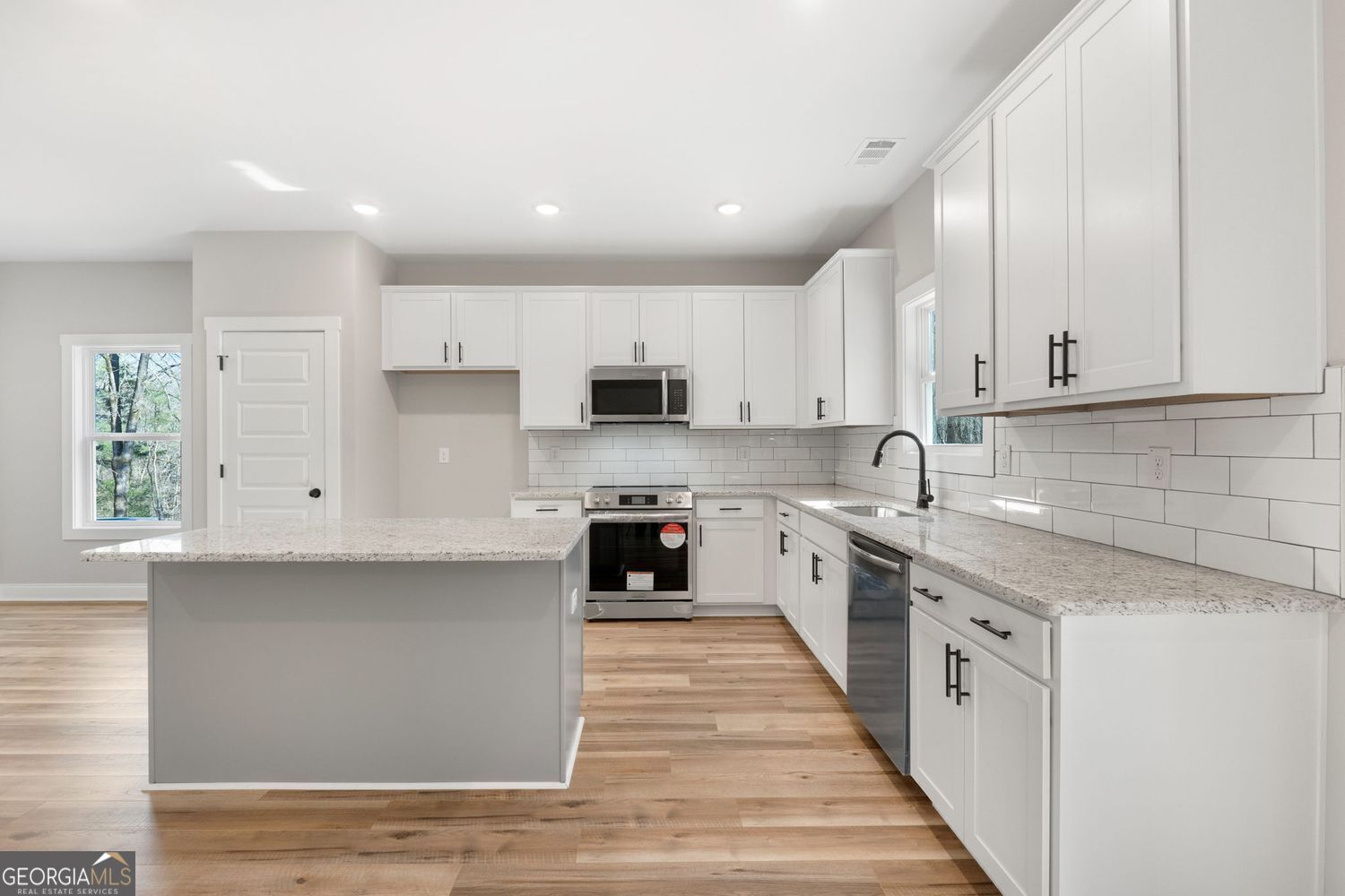 1578 English Road Forsyth, GA 31029 - Photo 15 of 39 a large kitchen with stainless steel appliances granite countertop a stove a sink and white cabinets