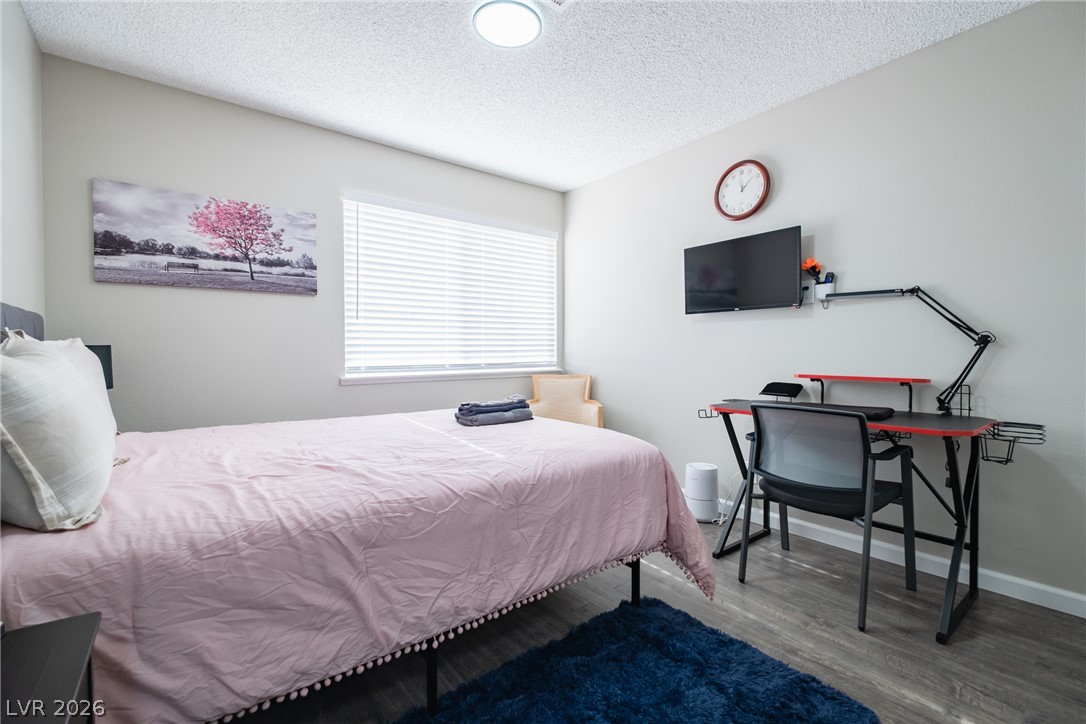 6356 West Viking Road Las Vegas, NV 89103 - Photo 37 of 51 Clean lines and durable wood-look flooring define this comfortable secondary bedroom.