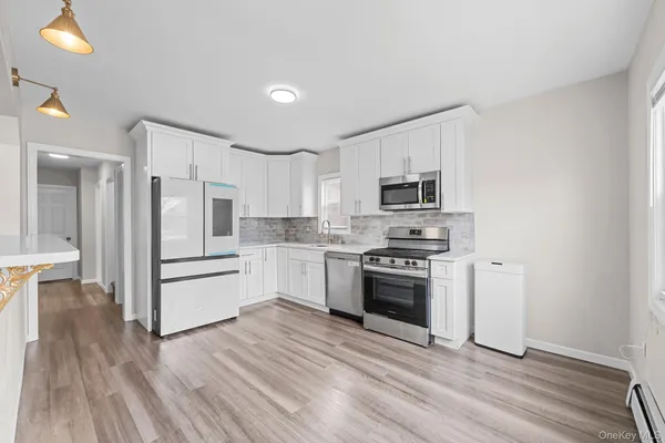 a kitchen with white cabinets and stainless steel appliances