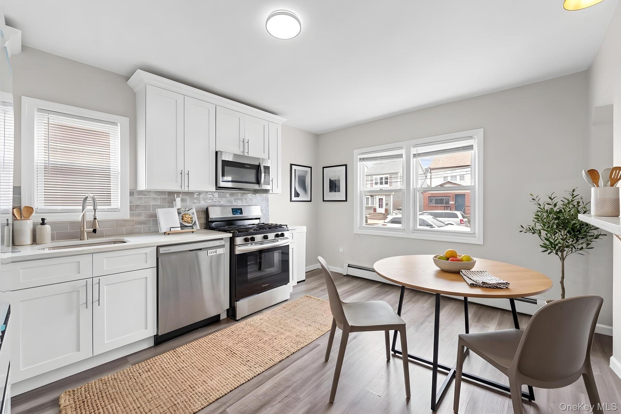20 Dewitt Street Valley Stream, NY 11580 - Photo 3 of 13 a kitchen with a dining table and chairs
