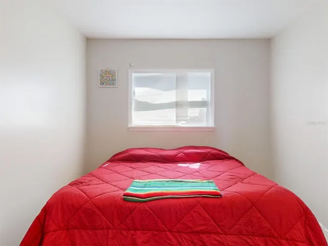a bedroom with a bed and a window