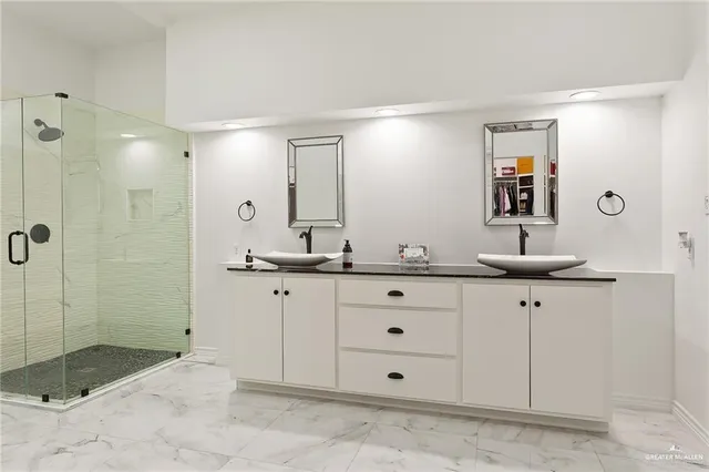 a bathroom with a granite countertop sink mirror and shower