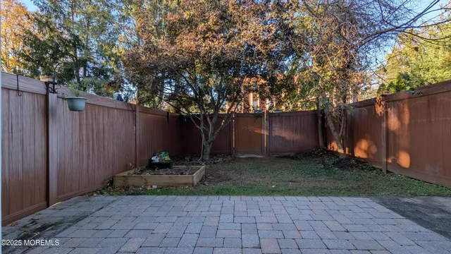 a view of backyard with wooden fence and a large tree