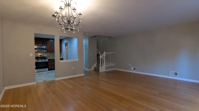 wooden floor in an empty room with a chandelier