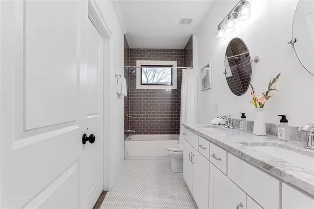 a bathroom with a granite countertop sink a toilet a vanity and bathtub