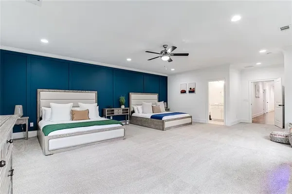 a spacious bedroom with a bed and a chandelier