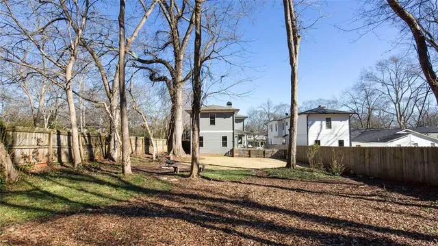 a house view with a yard covered with tall trees