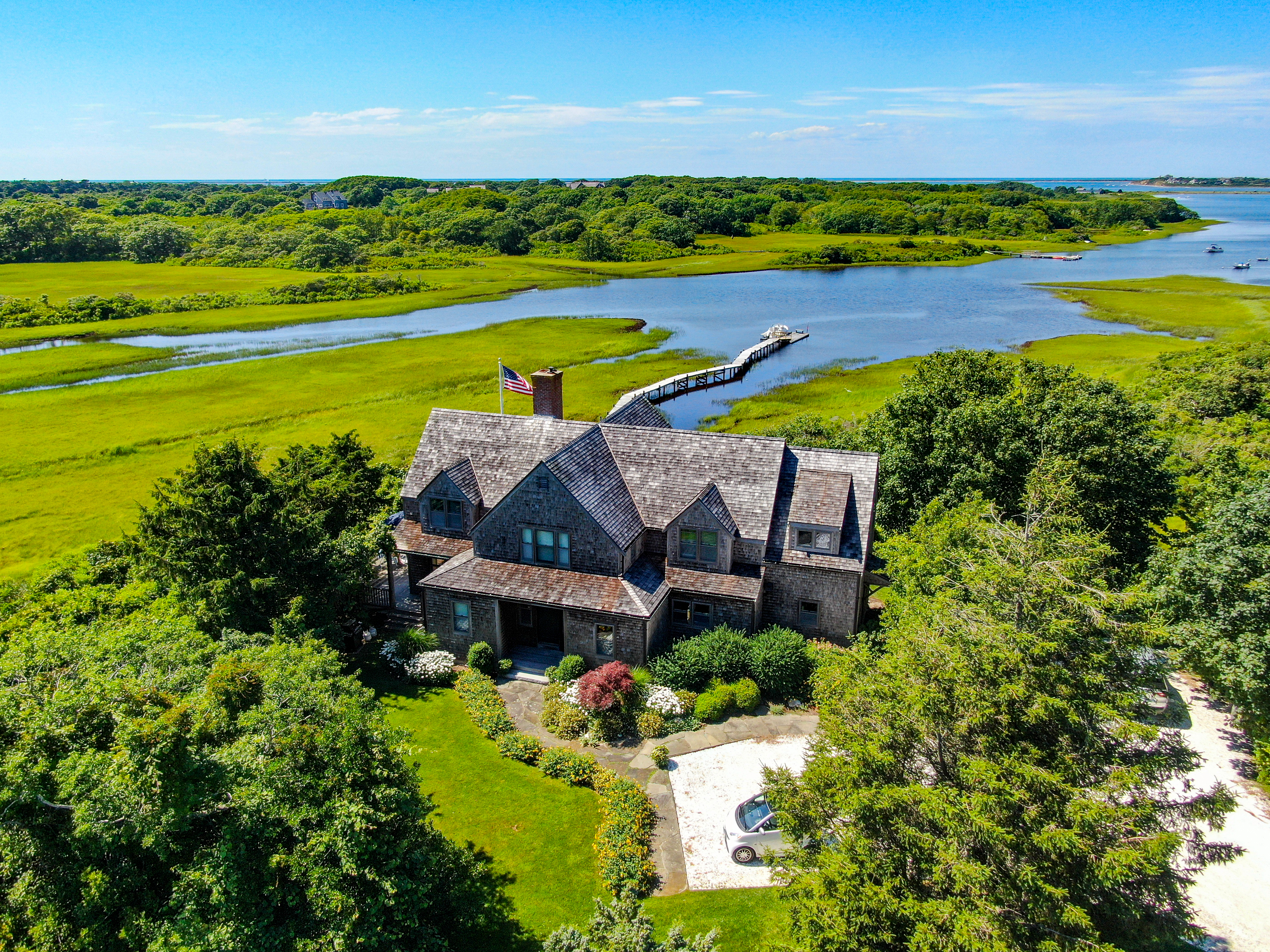 an aerial view of a house with a garden and lake view
