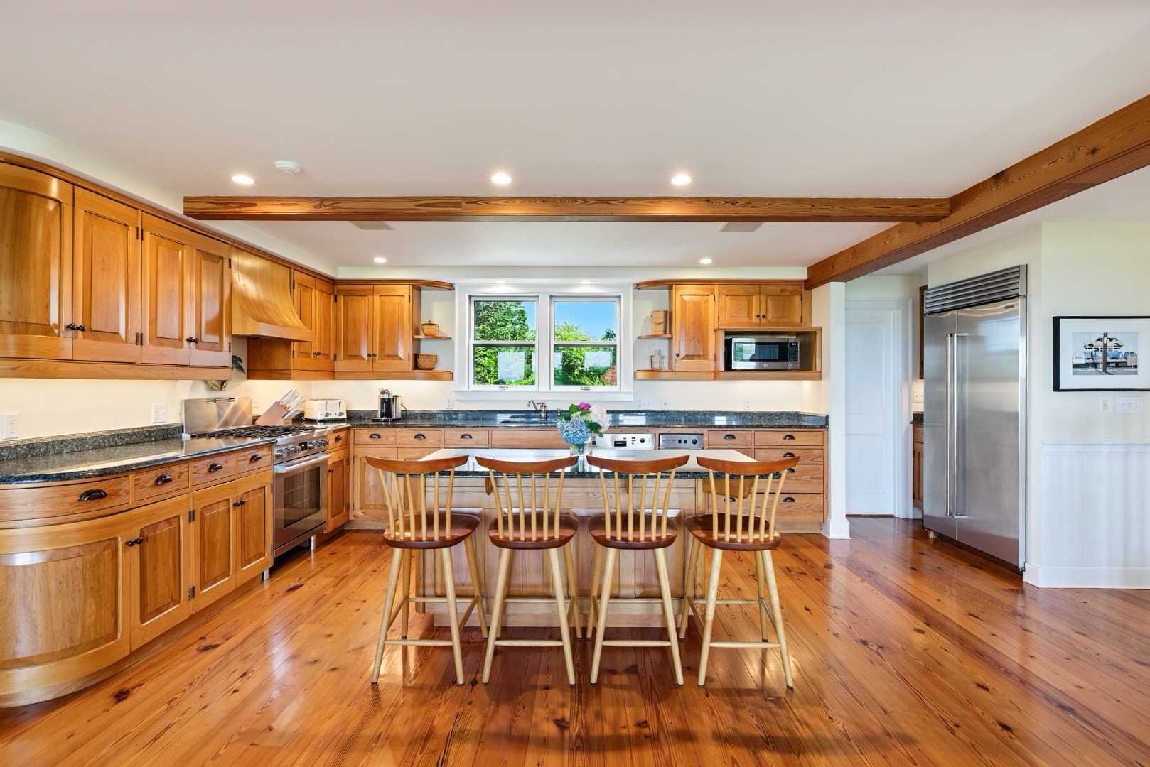 240 Polpis Road Nantucket, MA 02554 - Photo 6 of 45 a kitchen with stainless steel appliances kitchen island granite countertop wooden floors and white cabinets