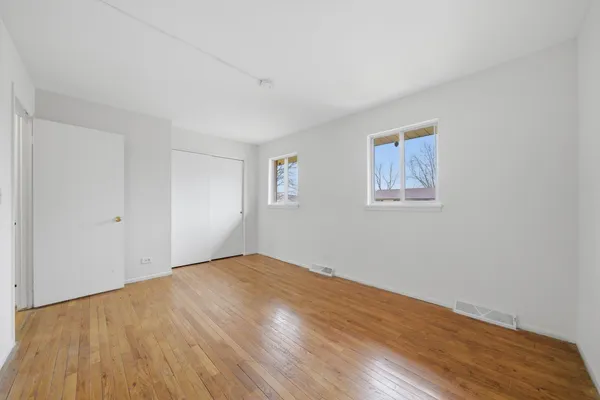 a view of empty room with wooden floor