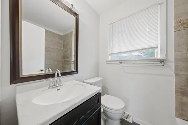 a bathroom with a sink a toilet and mirror